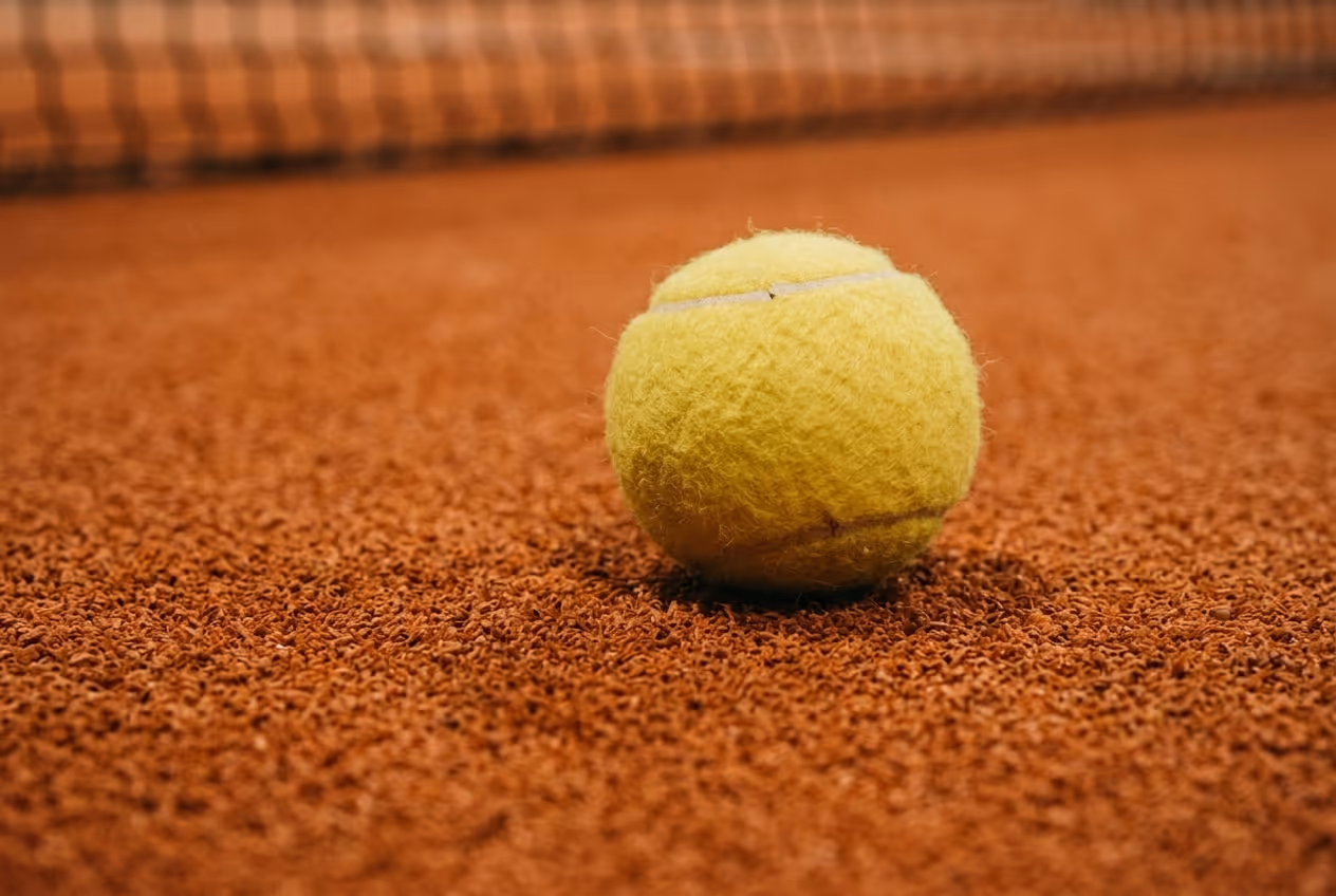 Gelber Ball auf einem roten Sandplatz