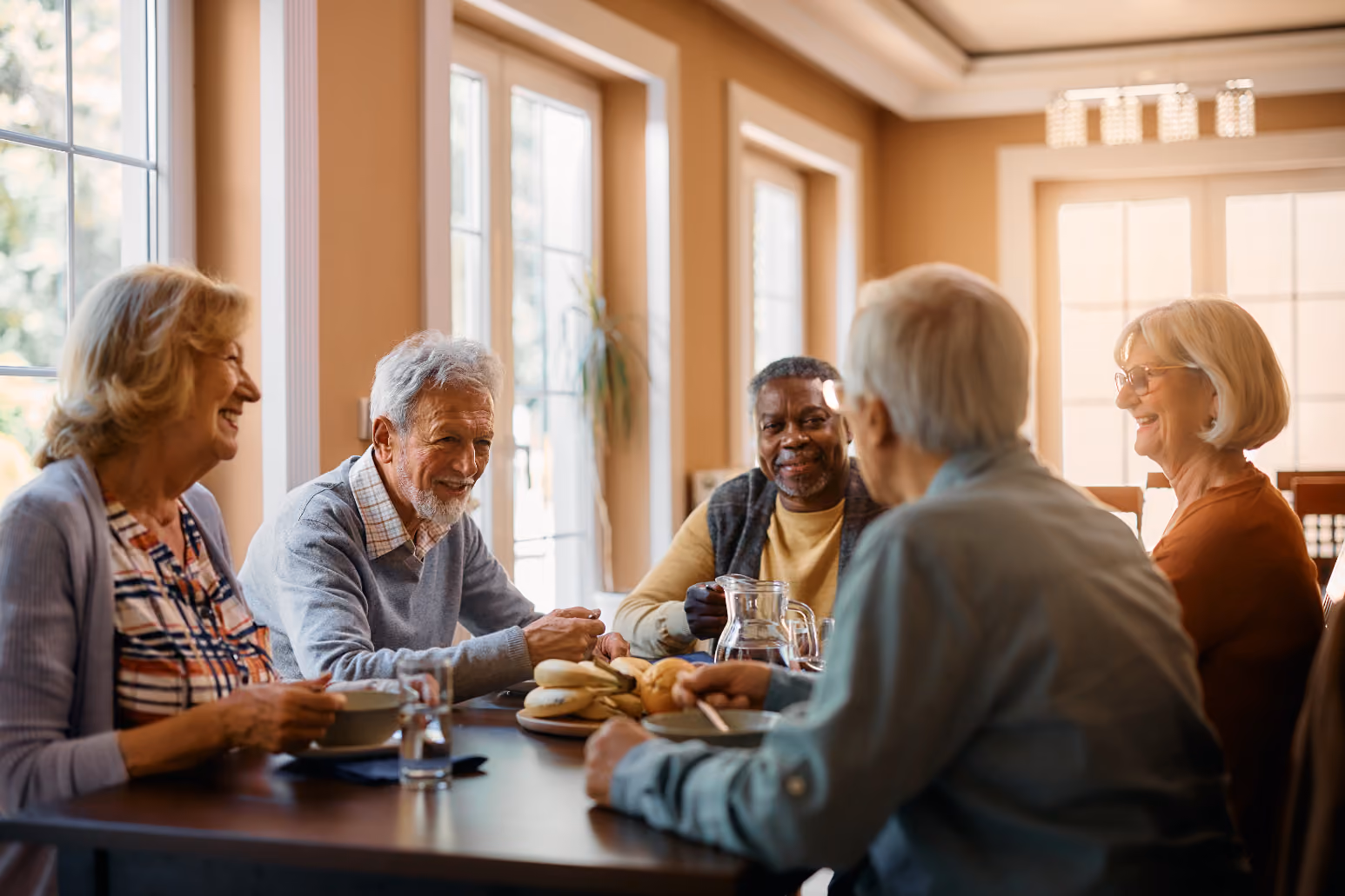 Seniors at table with pastries chatting sock image