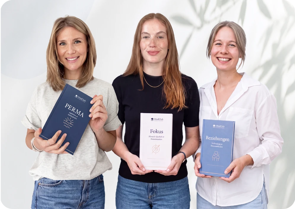 Drei MindClub-Psychologinnen halten die Workbooks PERMA, Fokus und Beziehungen