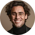 Smiling man with wavy hair, glasses, and black turtleneck against a brown background.
