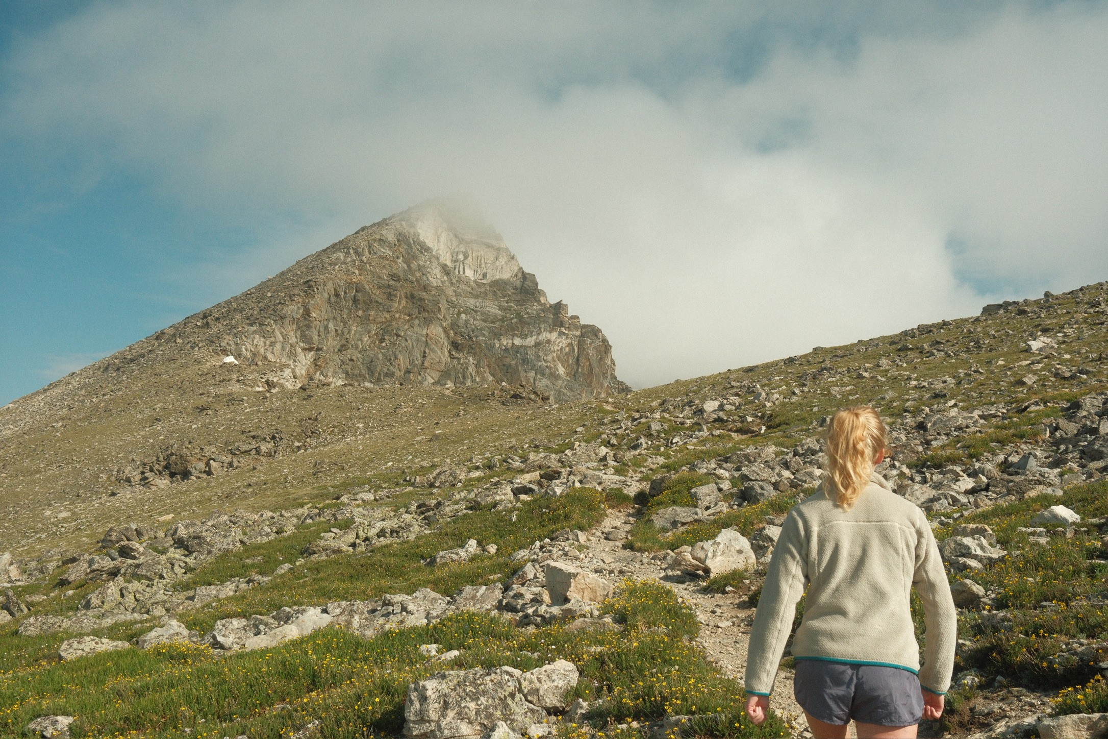 A hiker walking on up the trail toward the peak — strong and on their own