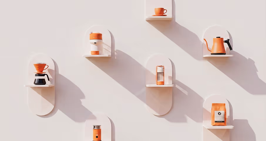 Orange coffee brewing tools and accessories displayed on white wall shelves.
