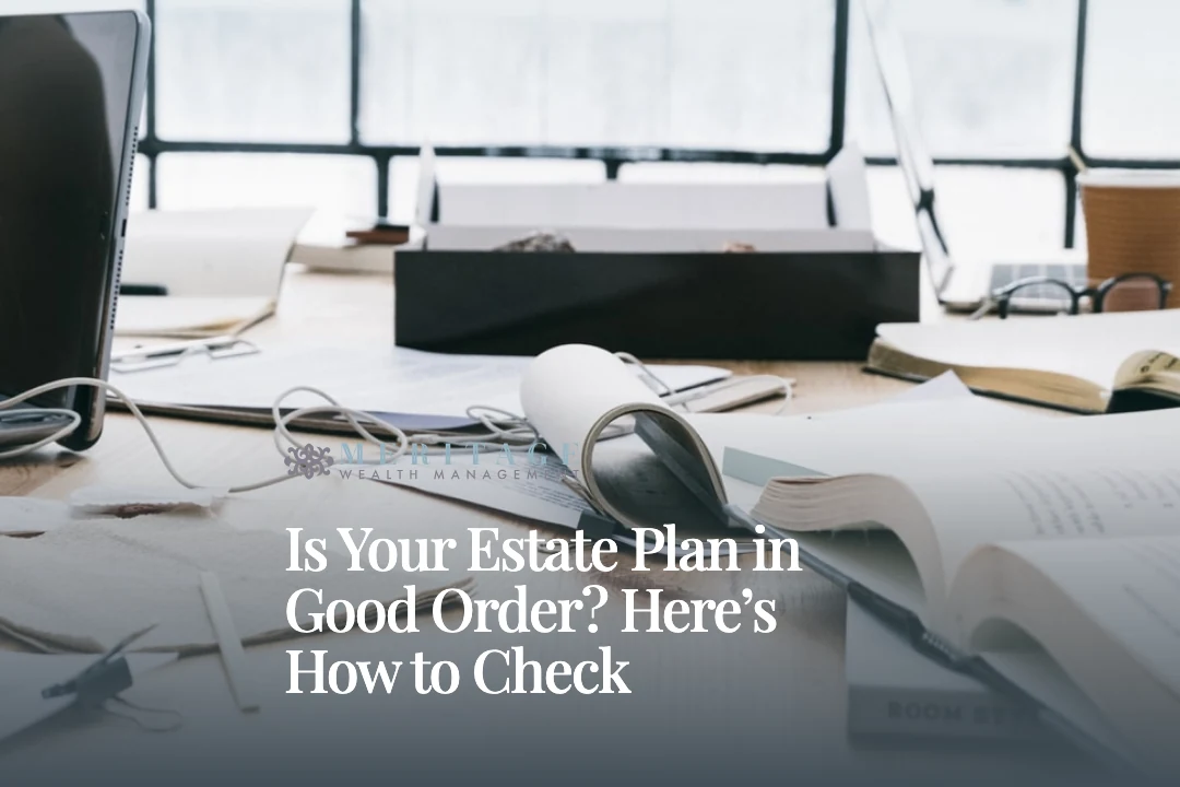 Desk covered with open books, papers & a laptop during an estate plan review