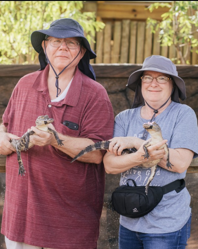 Two guests holding young alligators at Everglades Alligator Farm