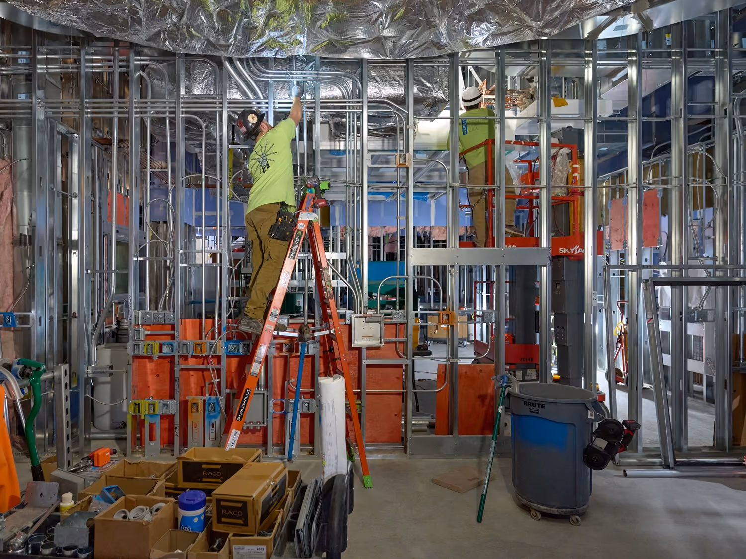 Electrician installing interior wiring at a construction site