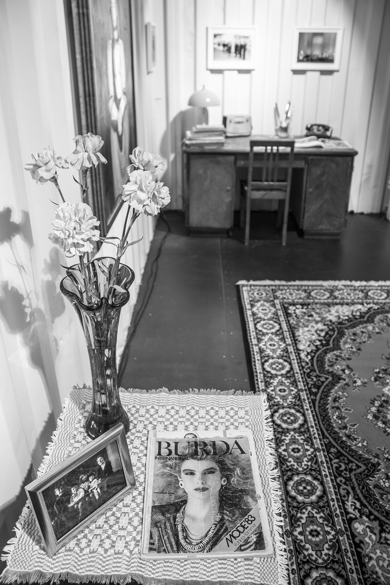 Ziedi vāzē un ierāmētas fotogrāfijas