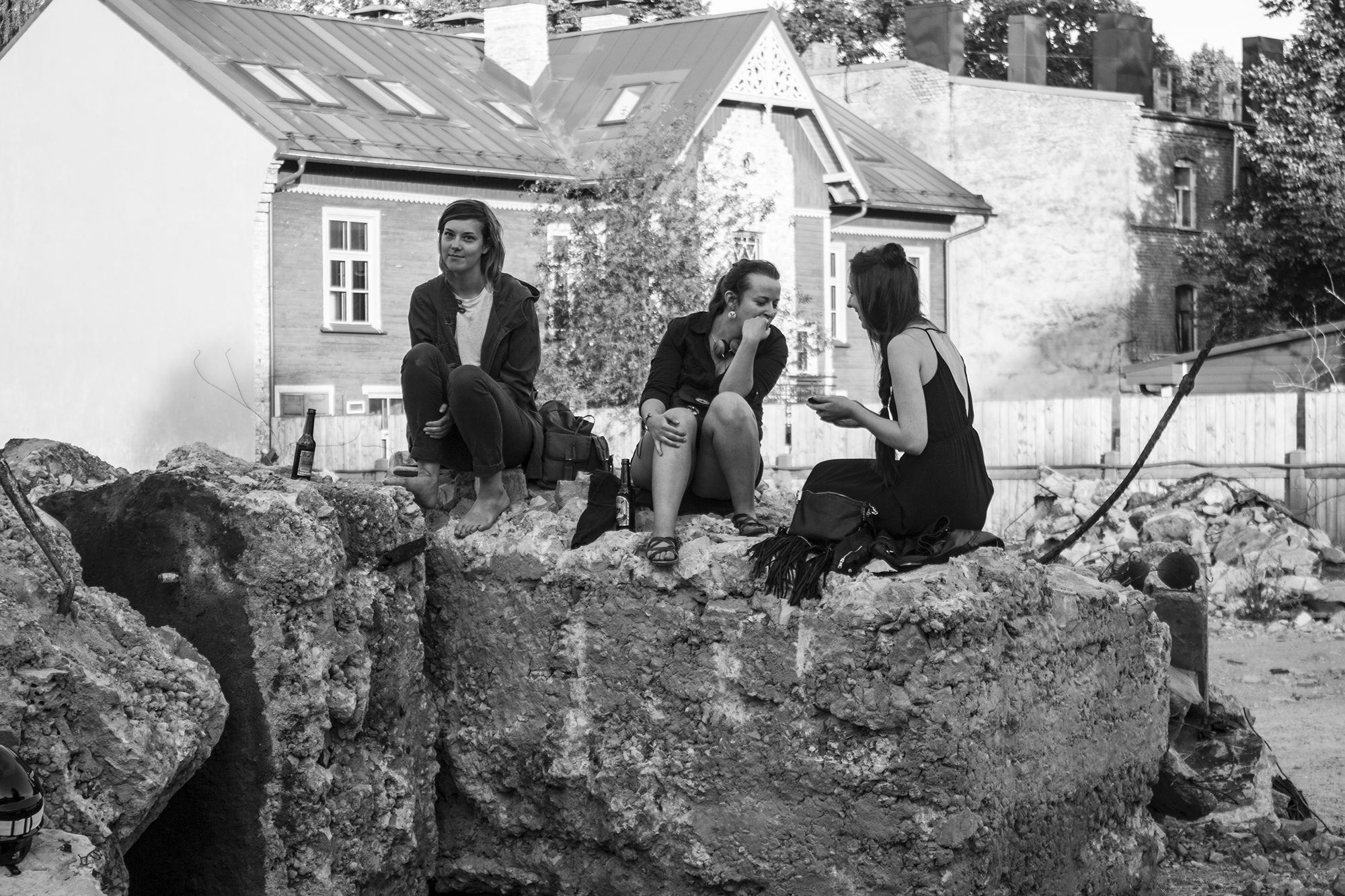 Apmeklētāji uz betona bluķiem; fonā Kalnciema ielas koka nams