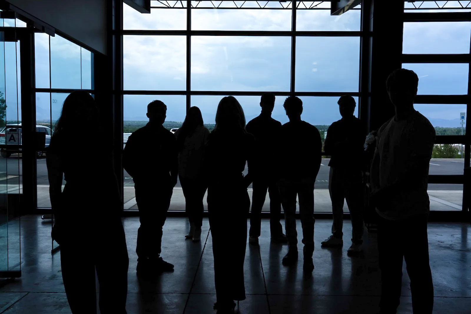 The PHENYX team silhouetted against floor-to-ceiling windows at dusk