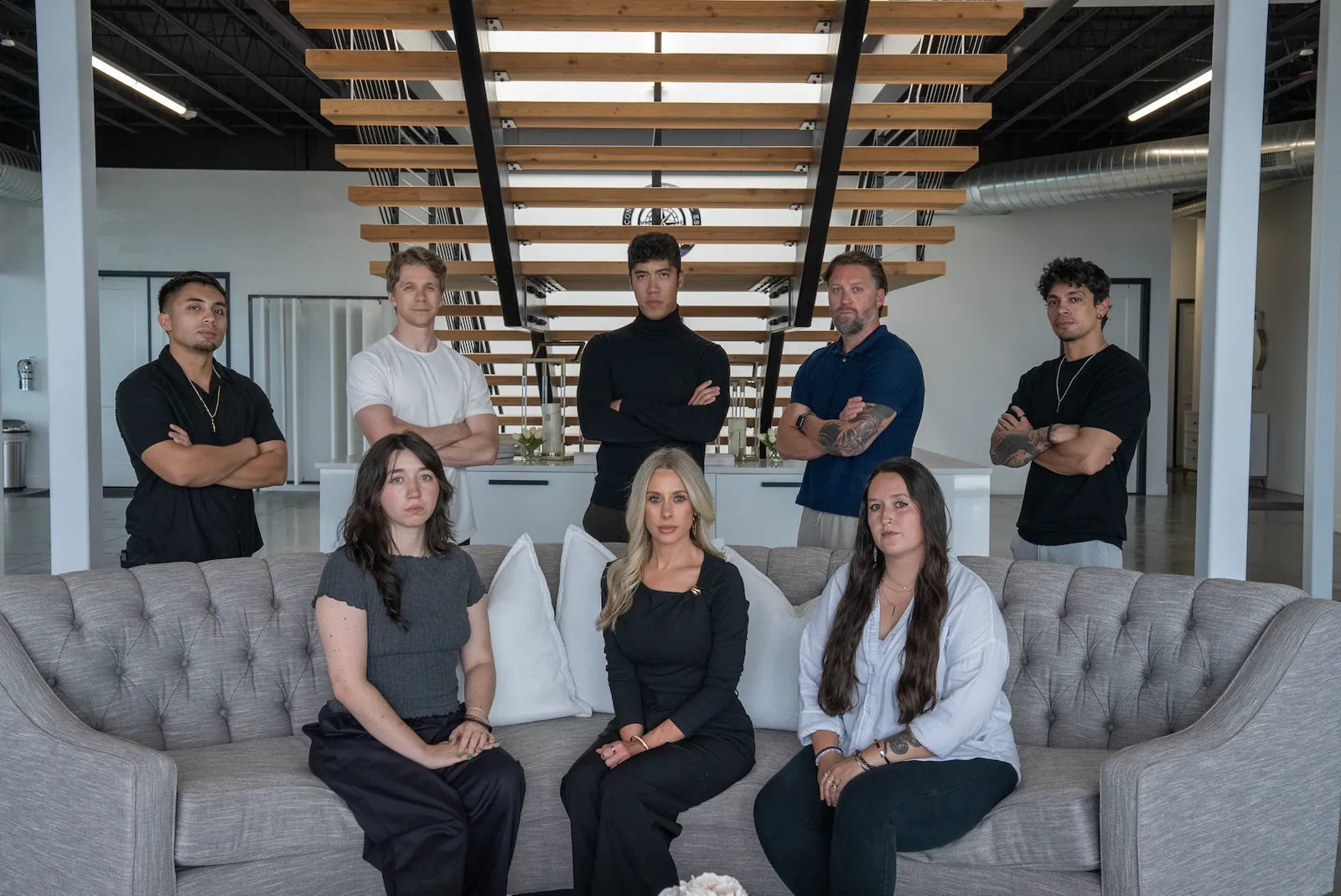 PHENYX team portrait with staff seated on a sofa and standing behind