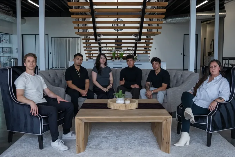 Six PHENYX team members seated around a coffee table in the studio lounge