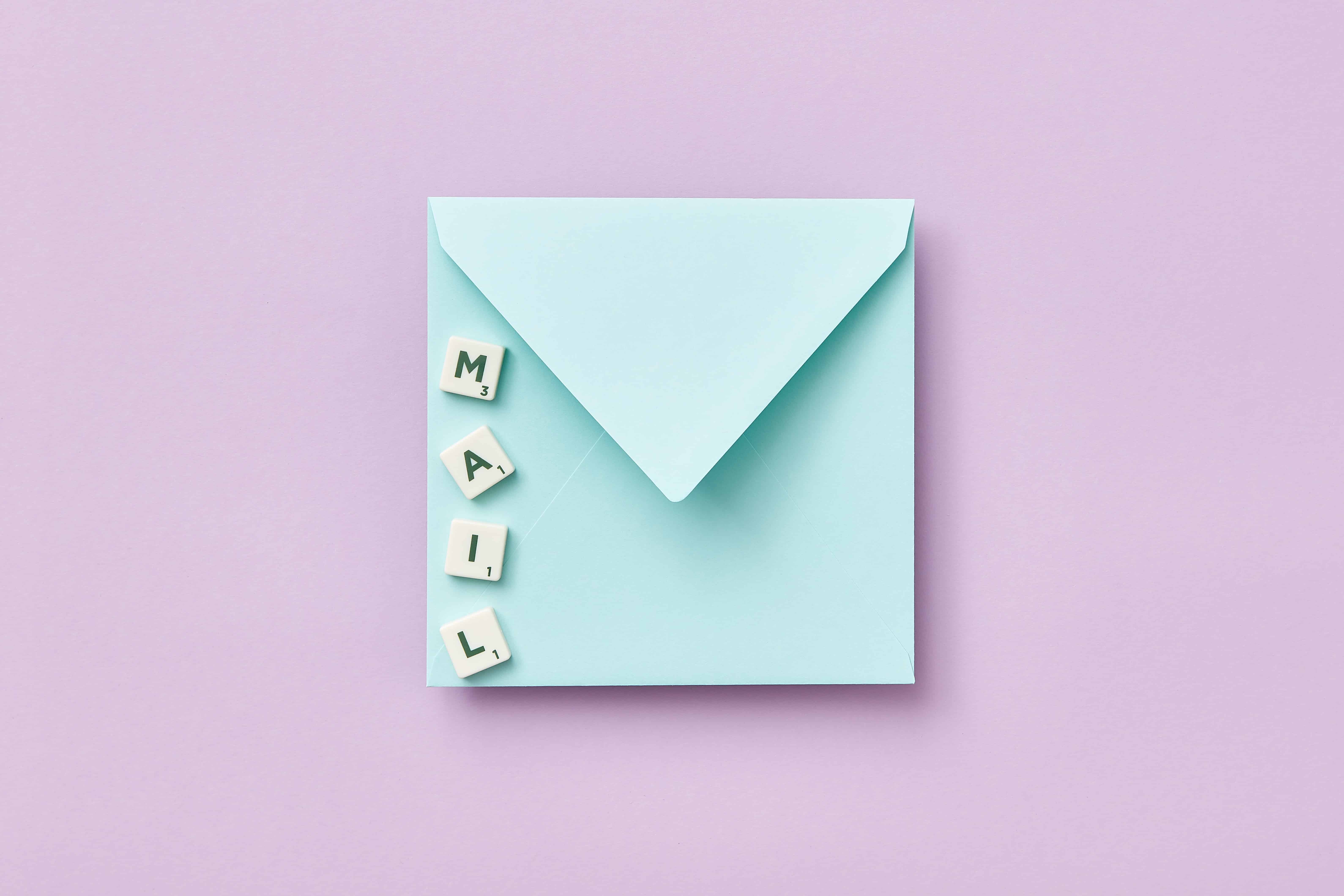 Envelope with letter spelled out mail on a purple background