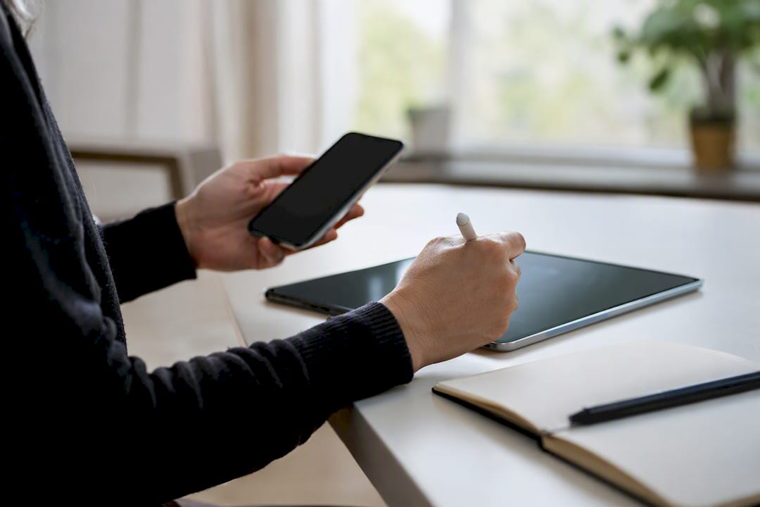 Hands managing social media content on tablets