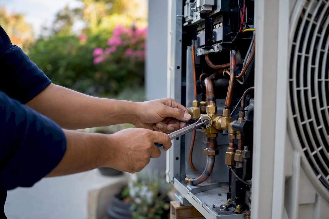 Hands repairing outdoor air conditioning unit