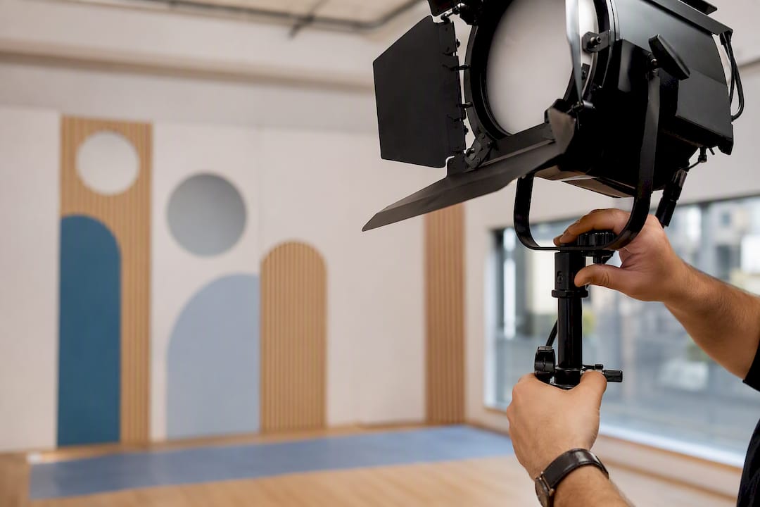 Hands adjusting studio lighting on corporate set