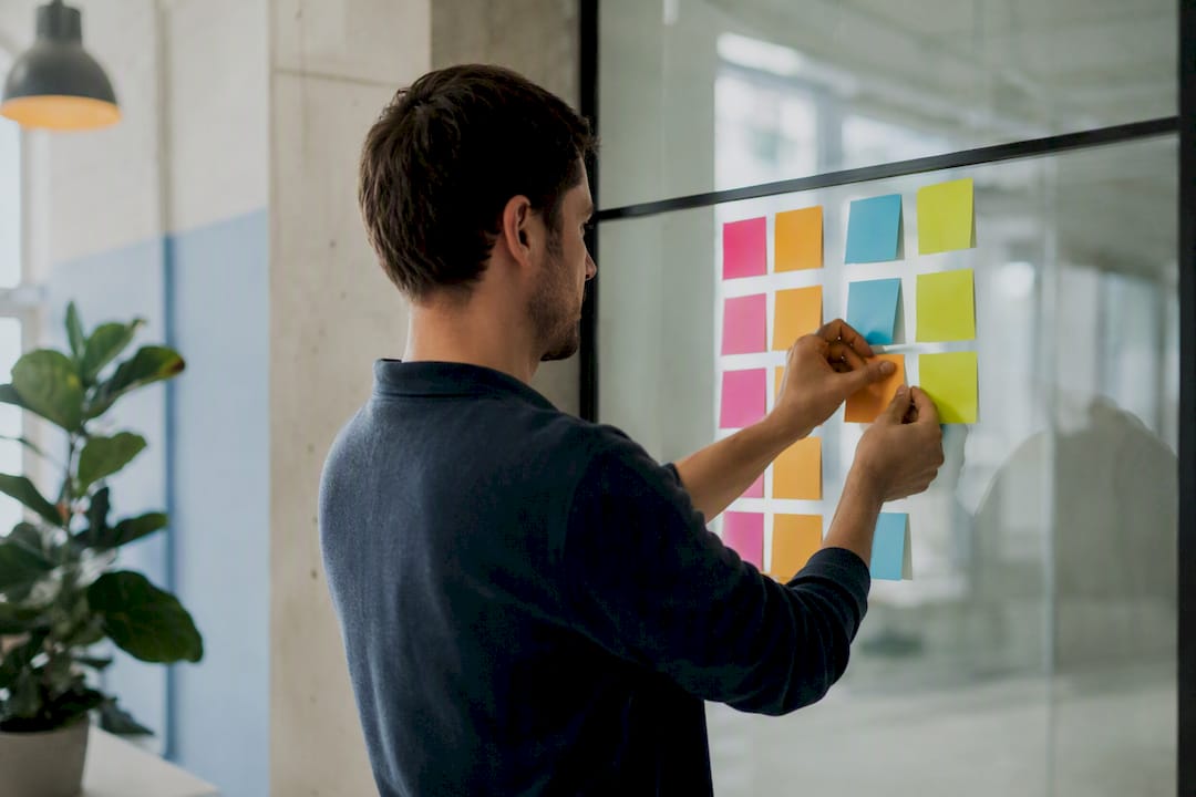 Hands arranging sticky notes checklist