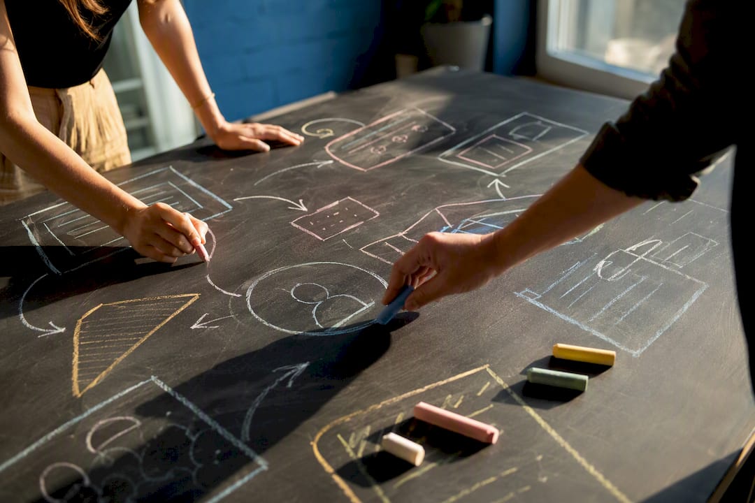 Hands sketching campaign strategy on wall