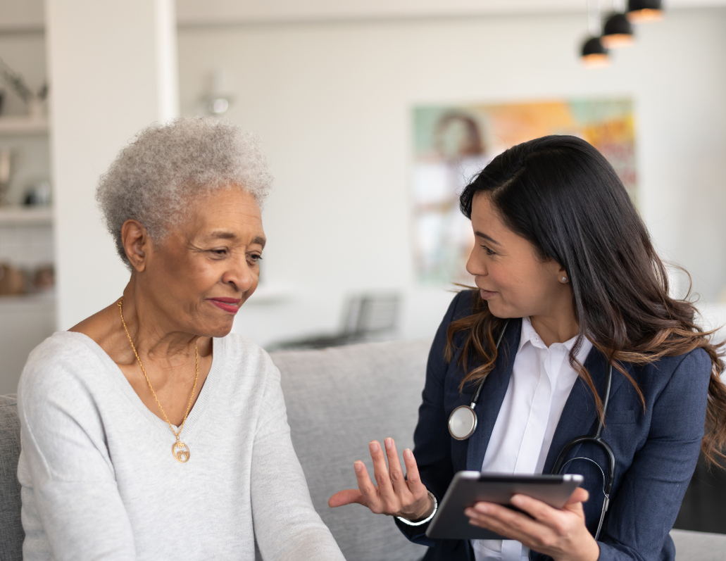 A clinician reviewing information on a tablet with a client