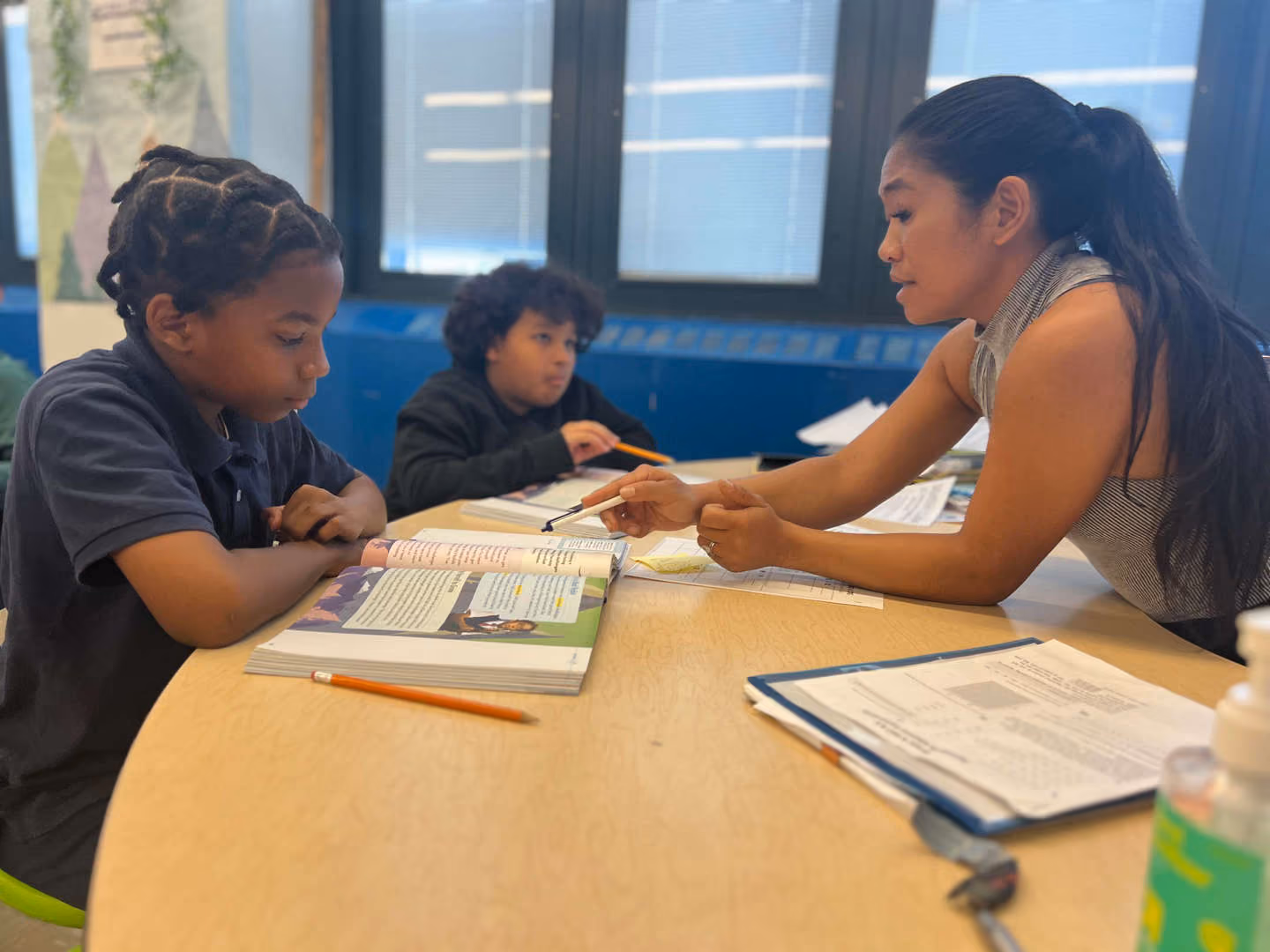 Teacher working one on one with student using open textbook