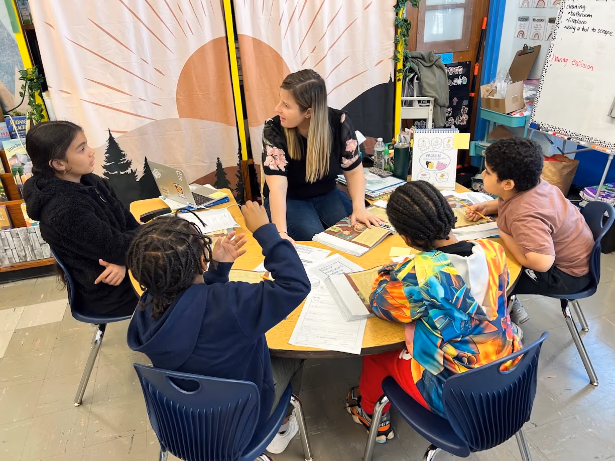 Teacher leads a small group reading lesson with four students