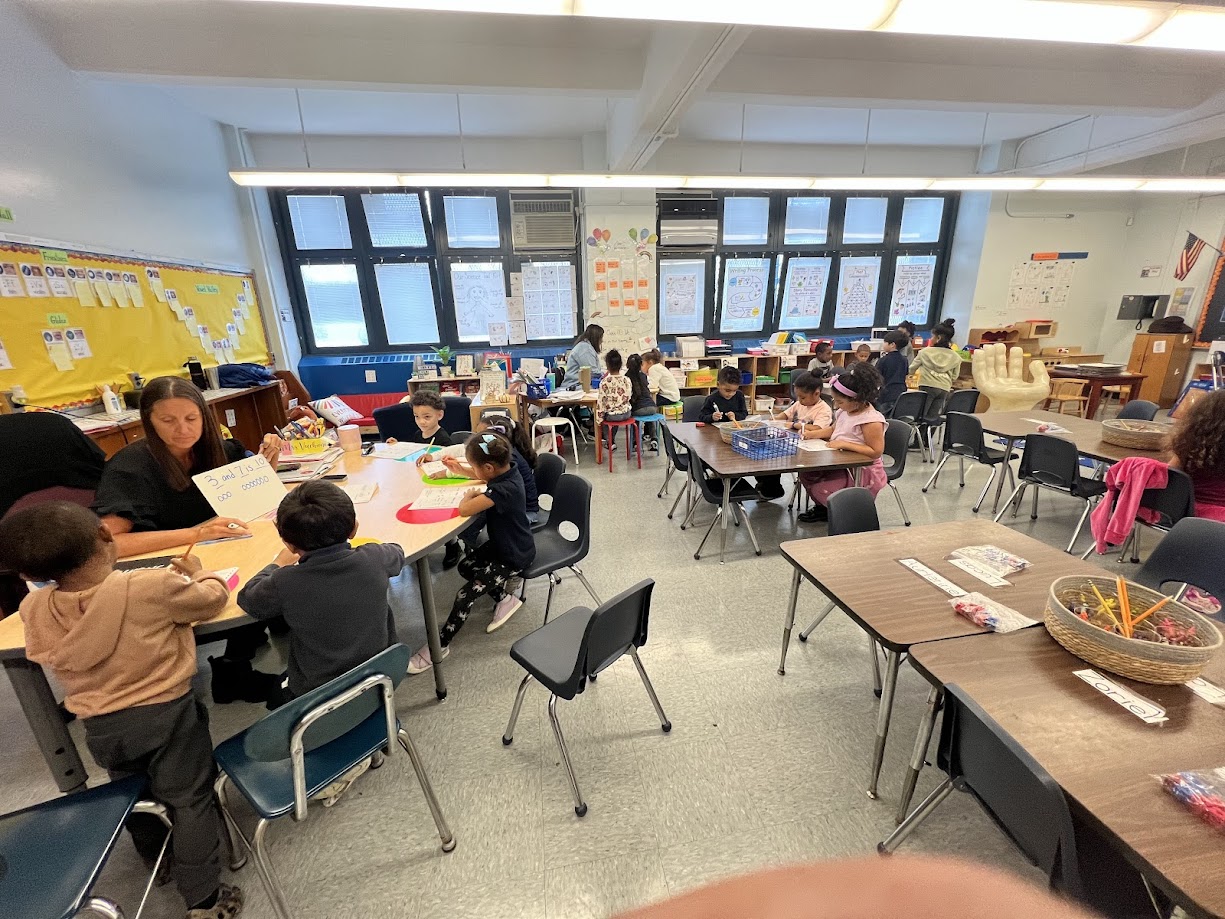 Teacher and students working at tables during classroom activity
