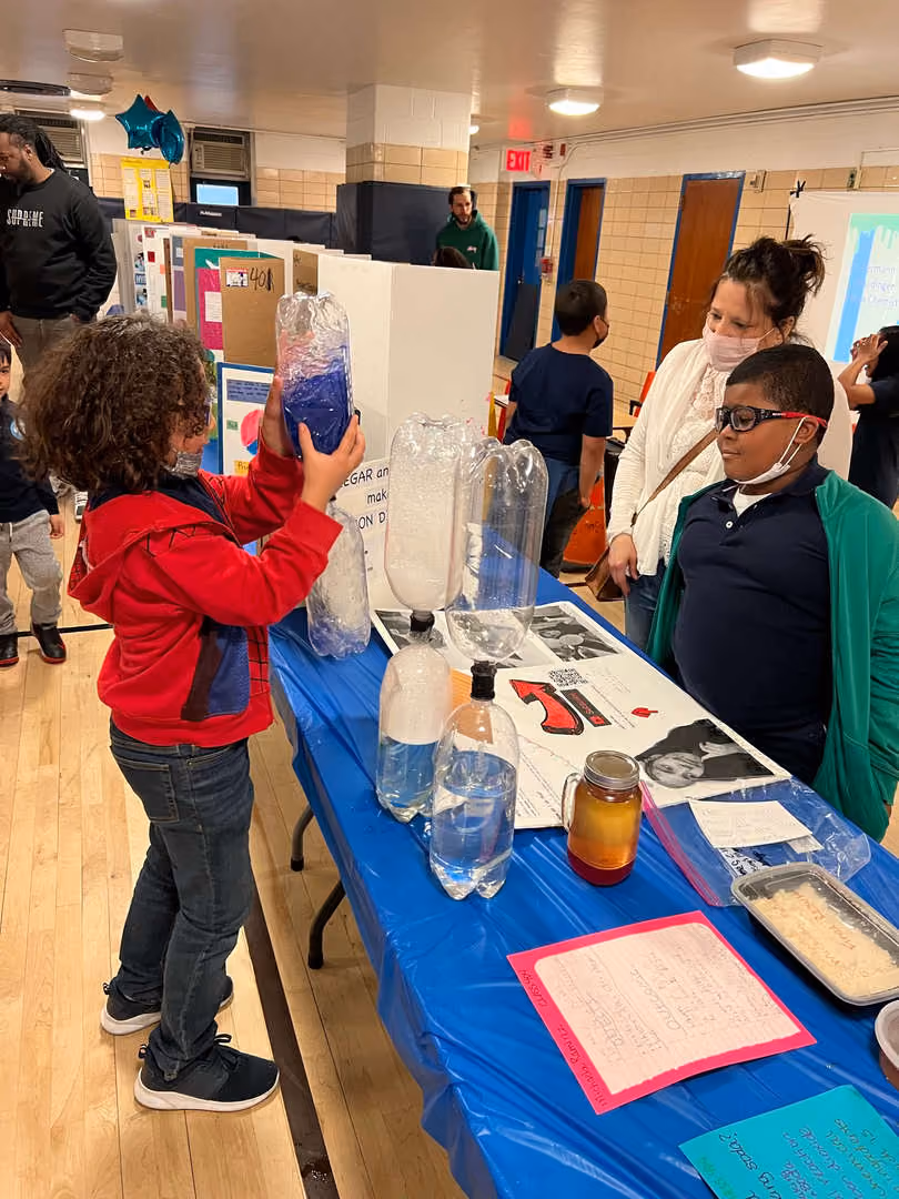 Students presenting liquid experiment at school science fair