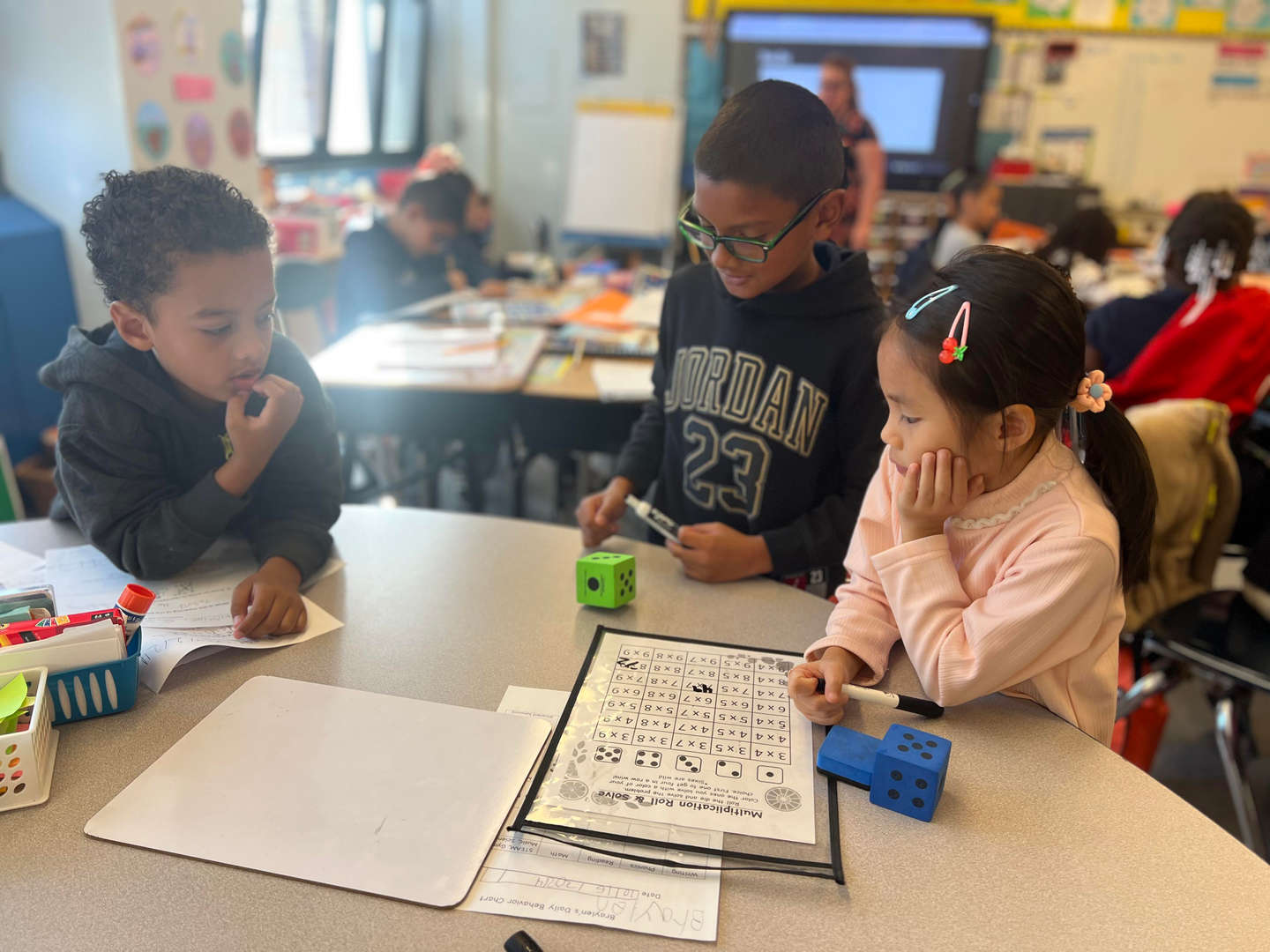 Three students working together on a multiplication dice activity