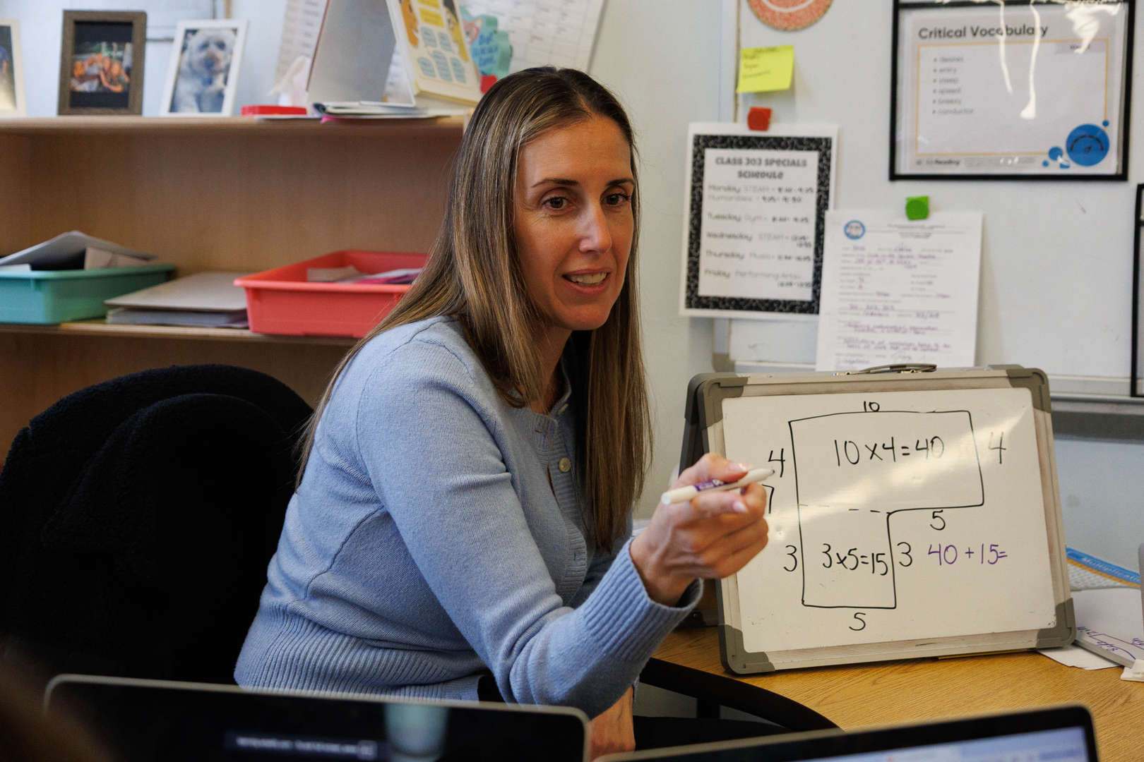 Teacher explaining multiplication using area model on whiteboard