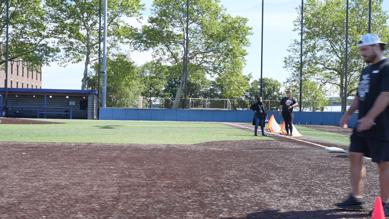 Students and staff during outdoor athletic drills on baseball field