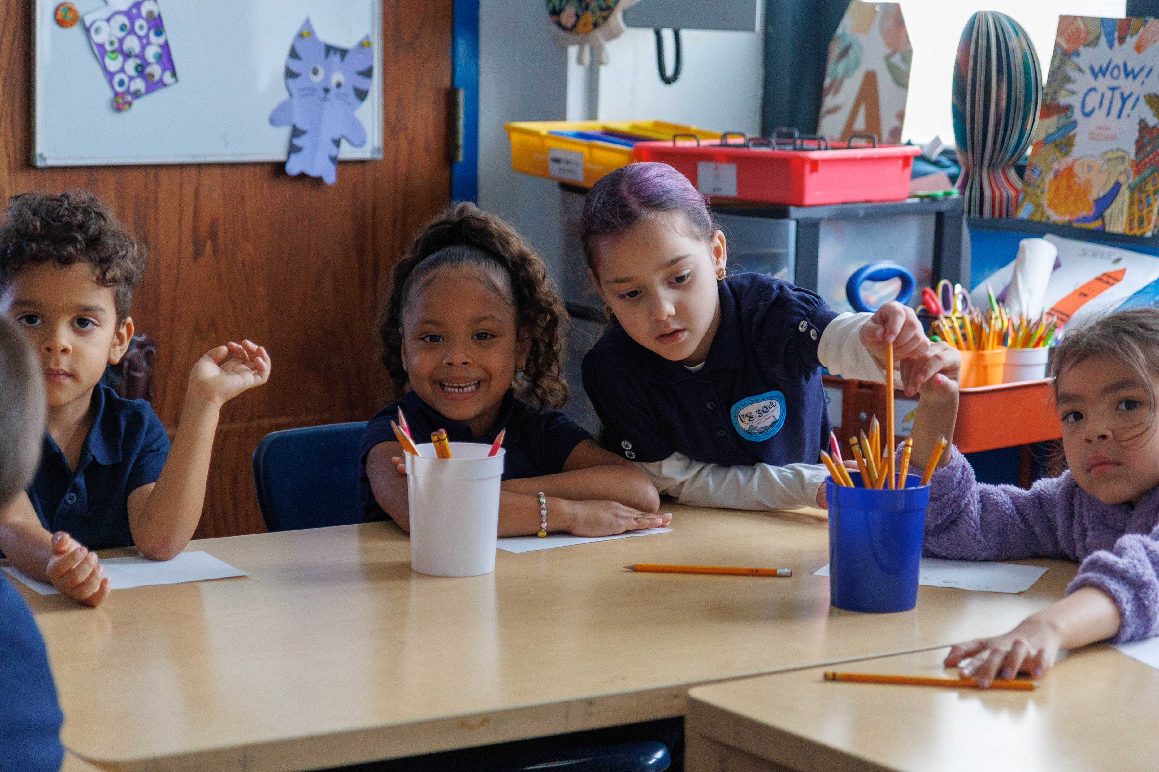 Young students in uniforms working together at a classroom table