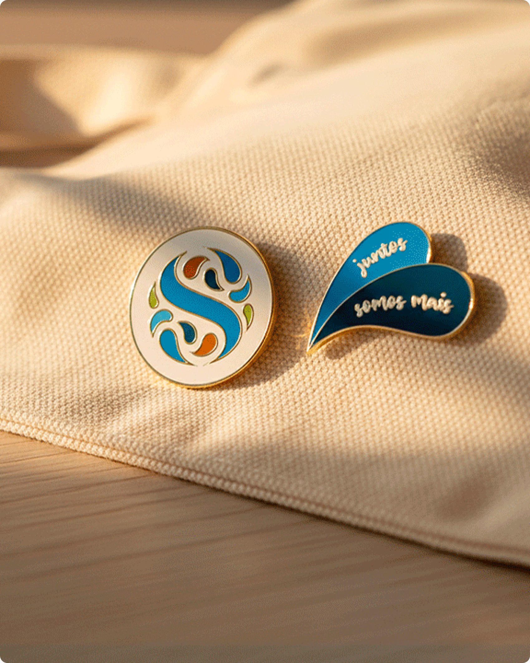 Pins com o monograma Savencia sobre tecido claro