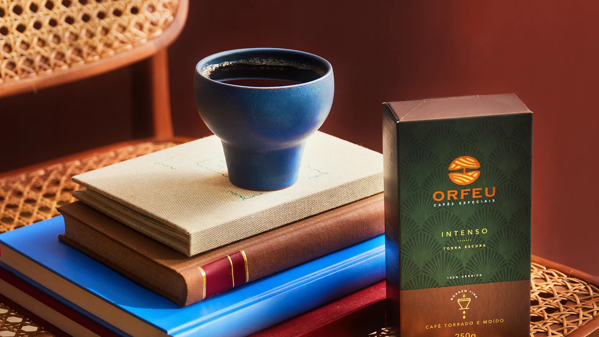 Café Orfeu em xícara de cerâmica sobre livros