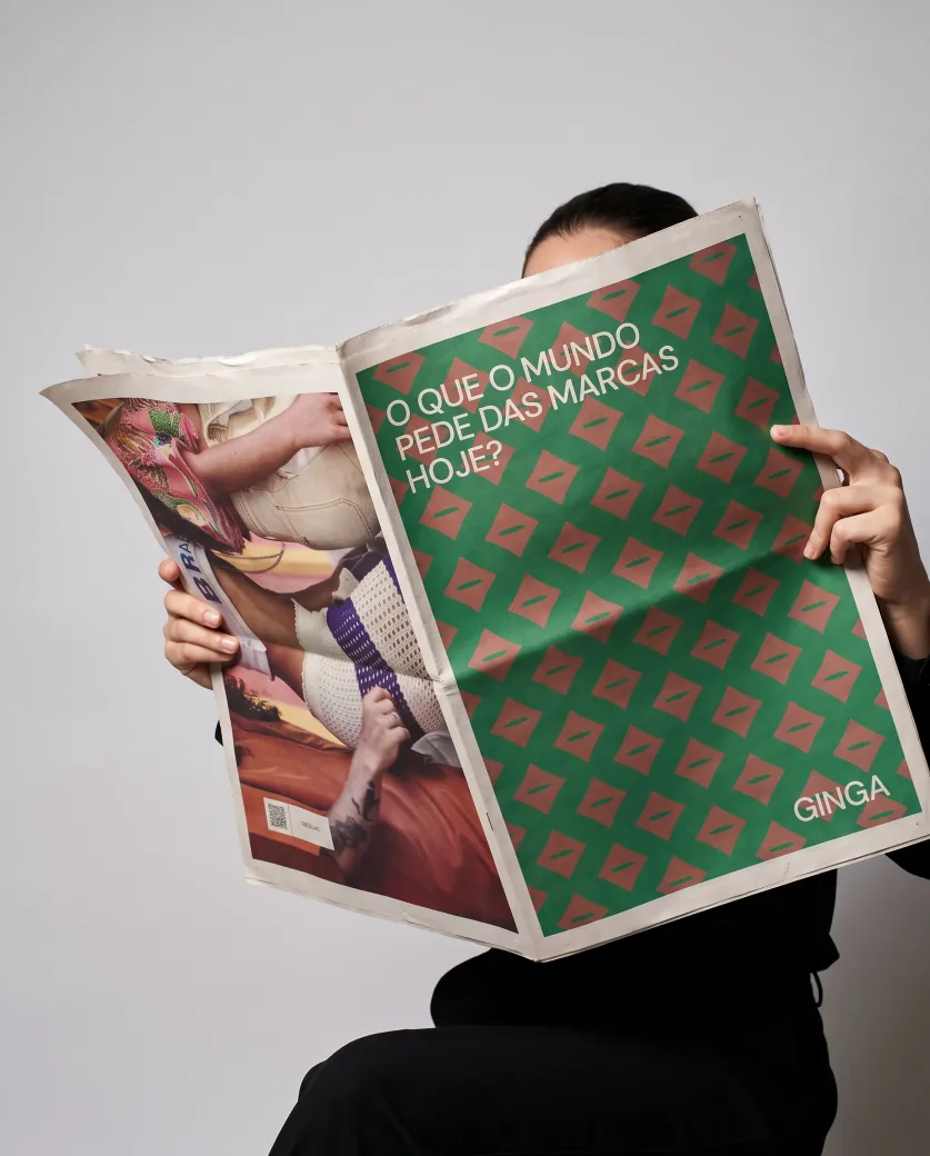 Pessoa lendo um jornal com estampa verde e rosa