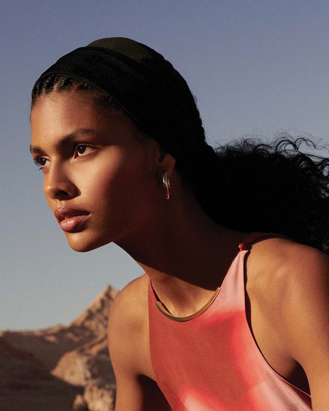 Modelo em roupa coral sob a luz do entardecer, campanha Animale