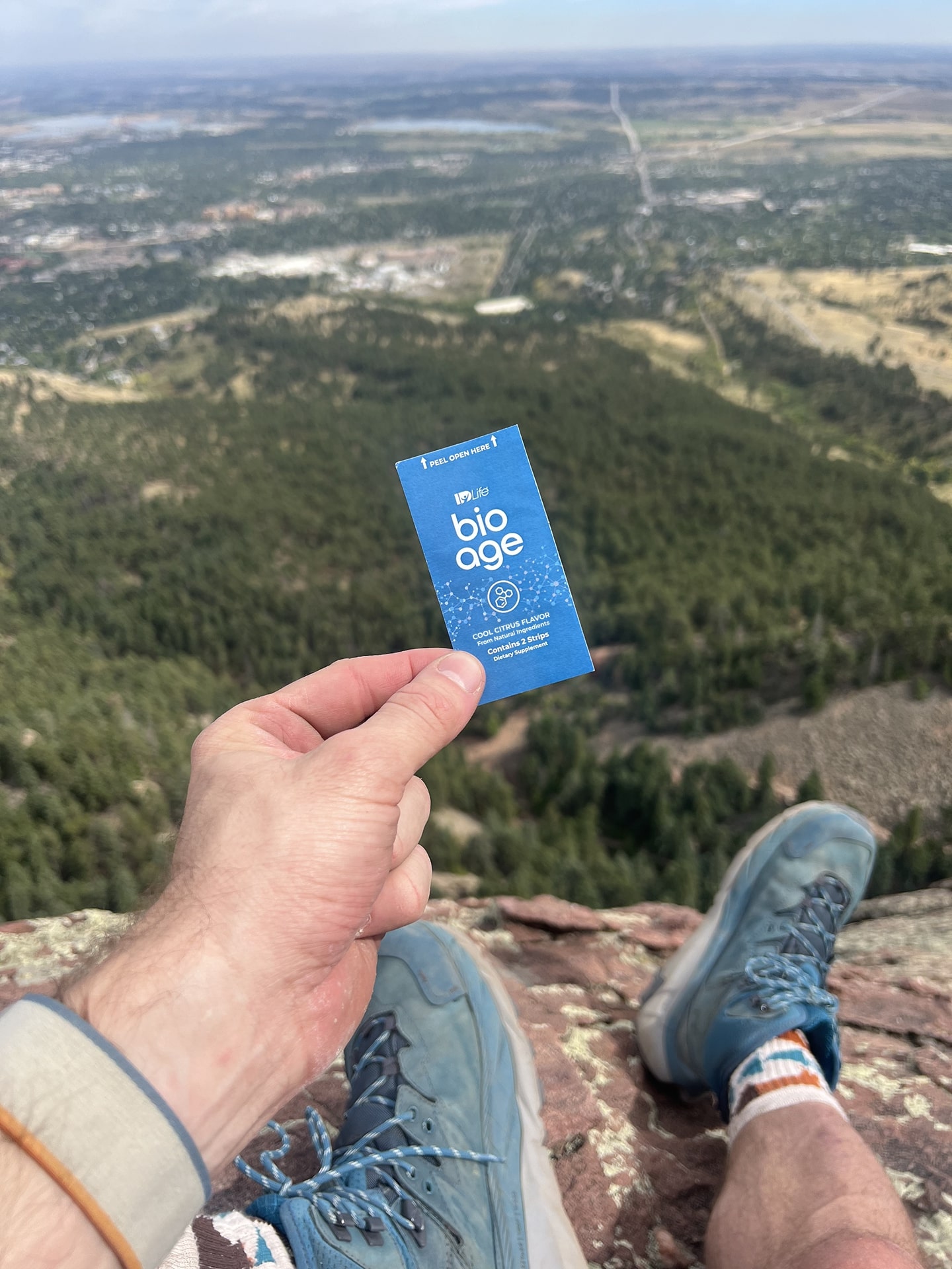 Holding a BioAge sachet above a mountain valley