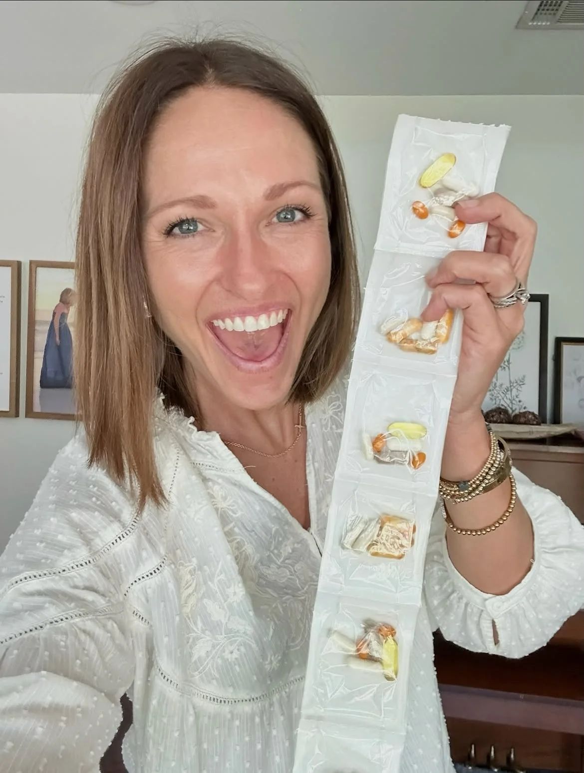 Woman holding up a strip of individually packed IDNutrition vitamins
