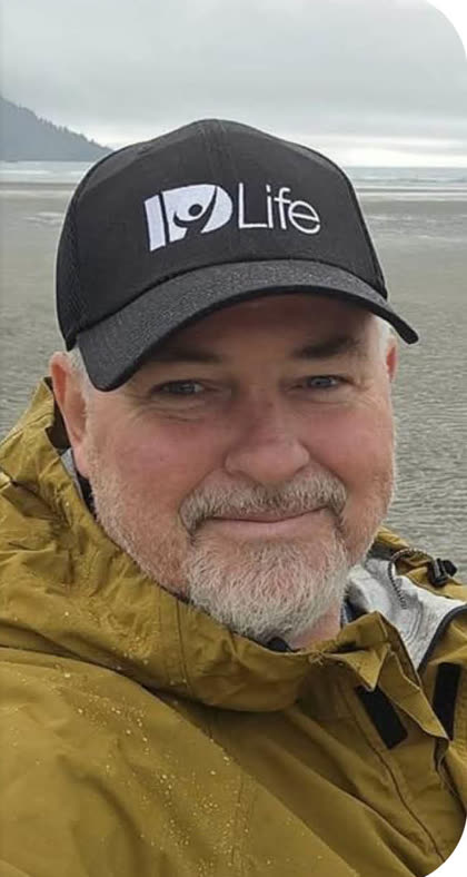 Dayman B. on a beach in an IDLife cap
