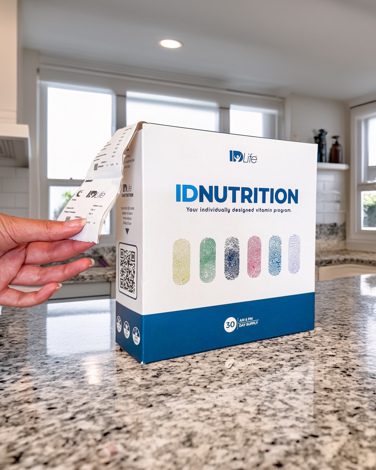 A daily vitamin packet being pulled from an IDNutrition box on a kitchen counter