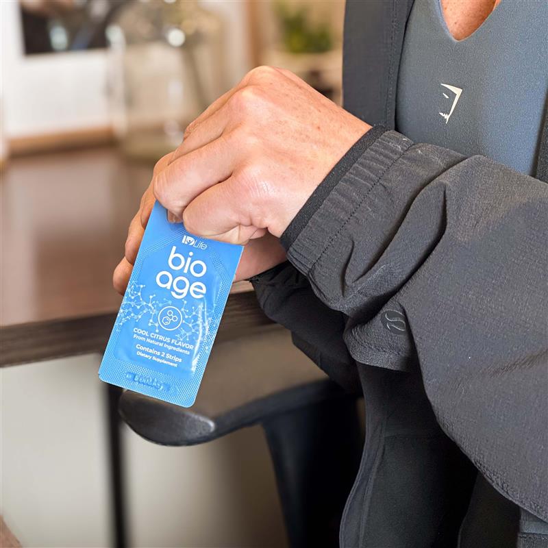 Man using a BioAge dissolvable strip while holding a sachet.