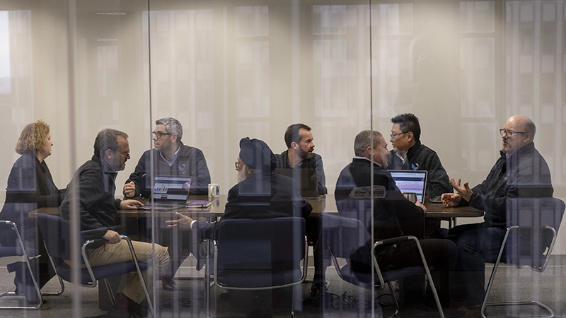 Veoci leadership in a meeting within a conference room.
