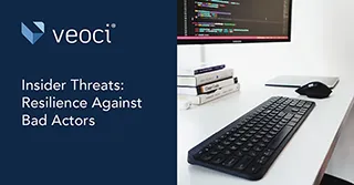 A keyboard, mouse, and monitor on a desk.