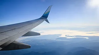 View of a landscape and airplane wing from a window in the cabin.