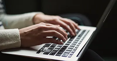 A person works on a laptop.