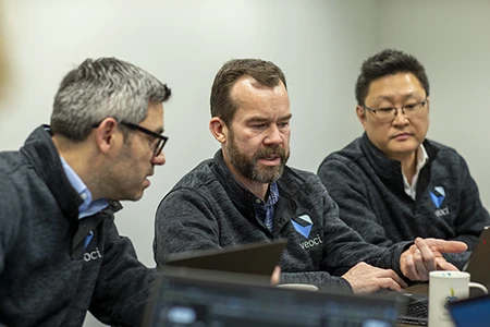 Members of the Veoci team discussing a solution.