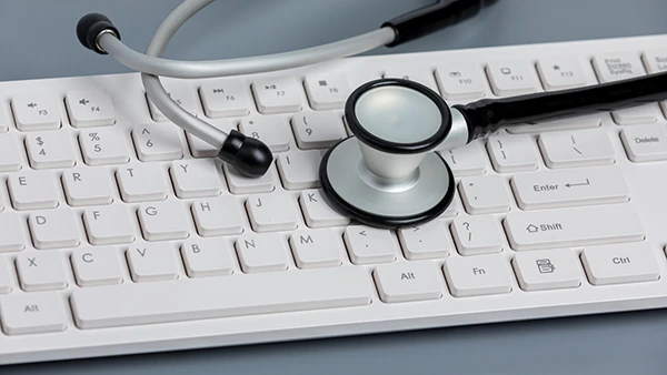 A stethoscope laid on top of a wireless keyboard.