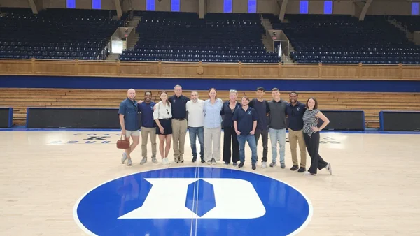 The Veoci Education team gathered at center court on the Duke University basketball court.