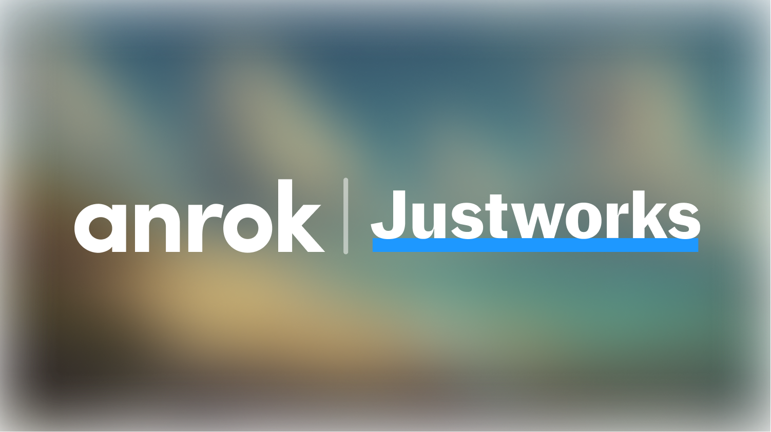 White text logos anrok and Justworks with a blue underline under Justworks on a blurred background.