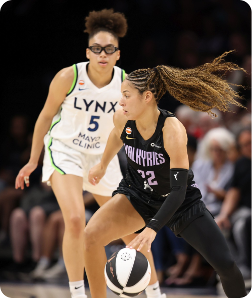 Valkyries player dribbling basketball while Lynx player defends during a game.
