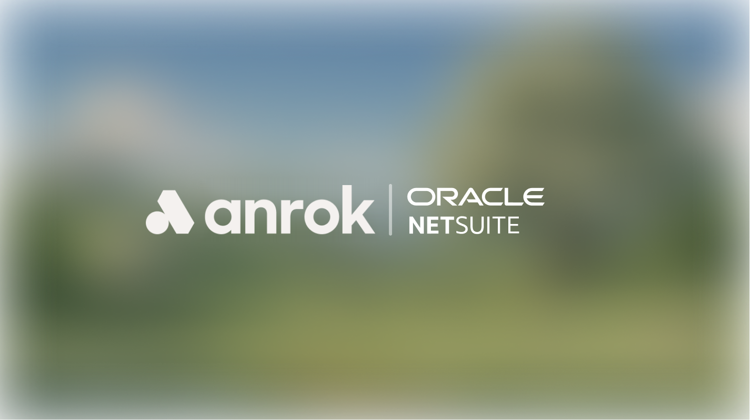 White Anrok logo left of a vertical line, with Oracle NetSuite logo on the right on a blurred background.