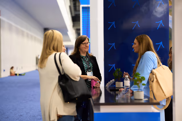 Waste Harmonics Keter team members talking with a visitor at their trade show booth
