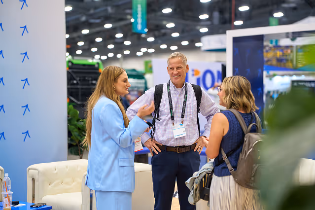 Three Waste Harmonics Keter colleagues talking together at the company trade show booth